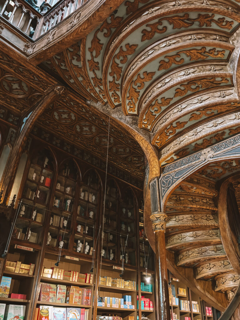 Close-up of decorative wood-carved shelves filled with classic literature in Porto