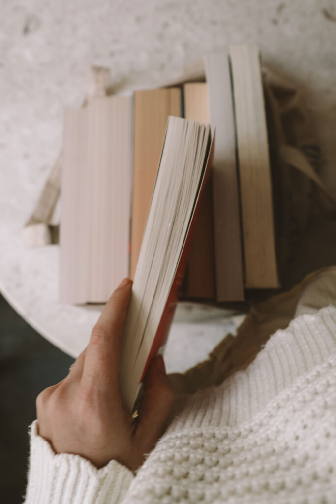 pile of classic novels on a desk