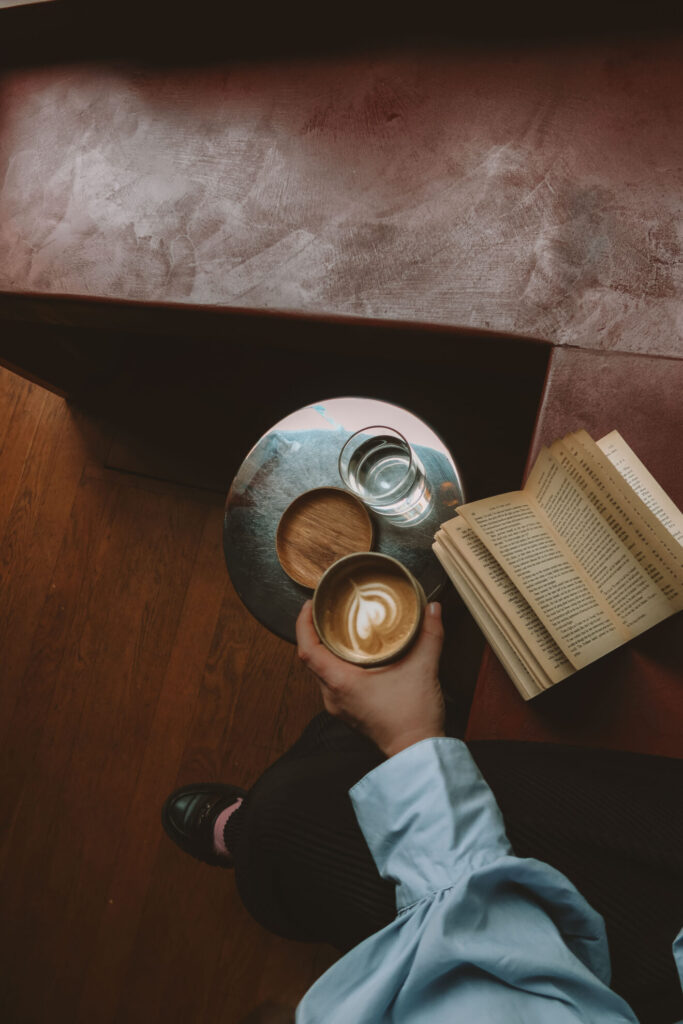 moody look of a coffee with latte art and a book