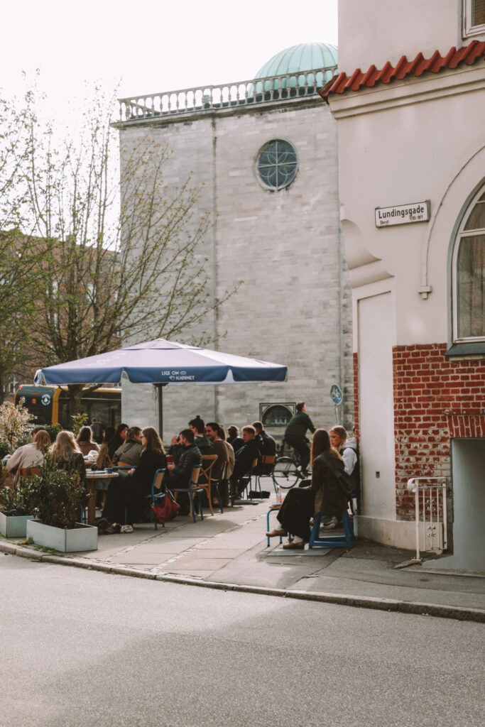 Leute die draußen auf der Terrasse sitzen und Kaffee trinken