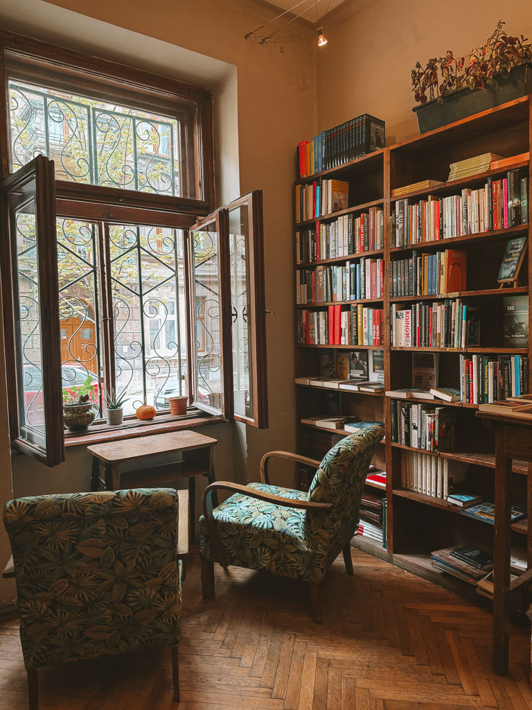 Books and café tables inside Massolit in Kraków