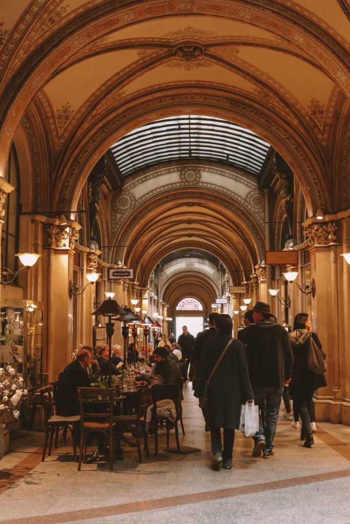 People shopping beneath the elegant historic arcades of Galerie Vivienne in Paris